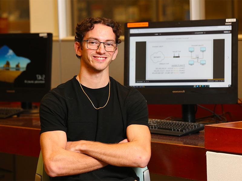 Student in front of computer monitors